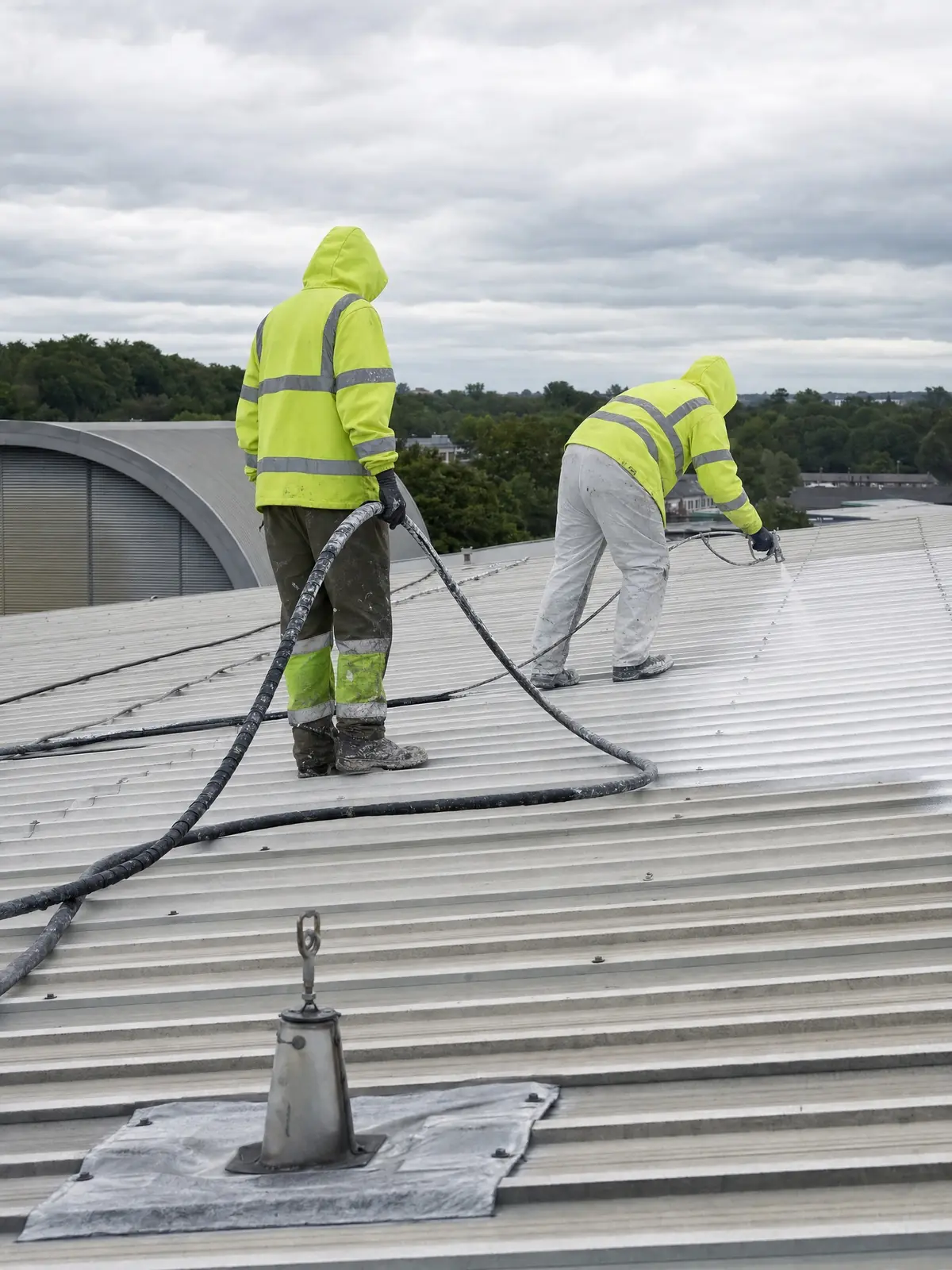 Operatives masking and preparing a commercial roof for spraying